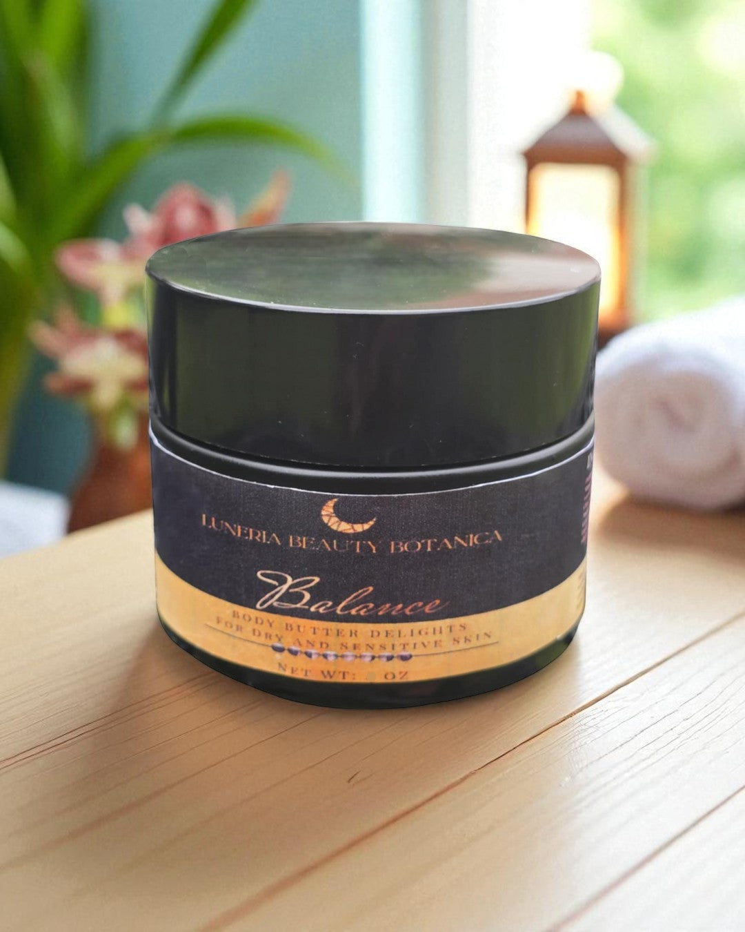 Cosmetic jar labeled 'Luneria Beauty Botanica' on a wooden surface with a blurred background