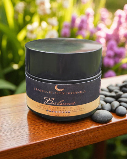 Cosmetic jar labeled 'Luneria Beauty Botanica' on a wooden surface with flowers in the background