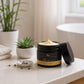 Cosmetic jar with open lid on a table with plants in the background