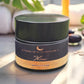 Cosmetic jar with 'Luneria Beauty Botanica' branding on a marble surface.