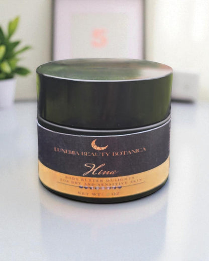 Luneria Beauty Botanica Hina body butter container on a white surface with a blurred background