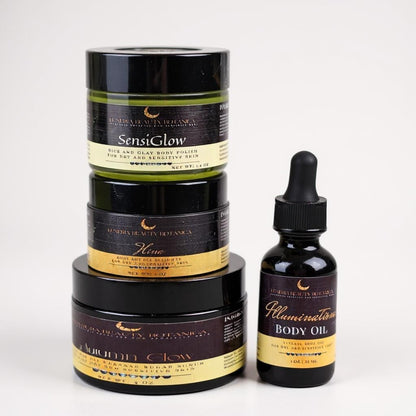Stack of skincare products with a bottle of Illumination body oil on a white background