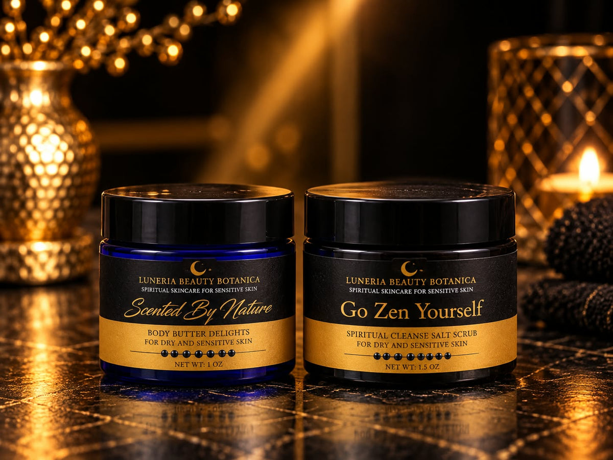 Two jars of Luneria Beauty Botanica skincare products on a dark textured surface: a smaller blue jar labeled 'Scented By Nature' and a larger black jar labeled 'Go Zen Yourself' with gold lettering.